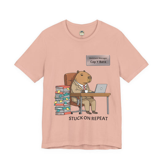Gray T-shirt featuring a capybara in a suit with "Stuck on Repeat" text and personalized nameplate, by Printify.