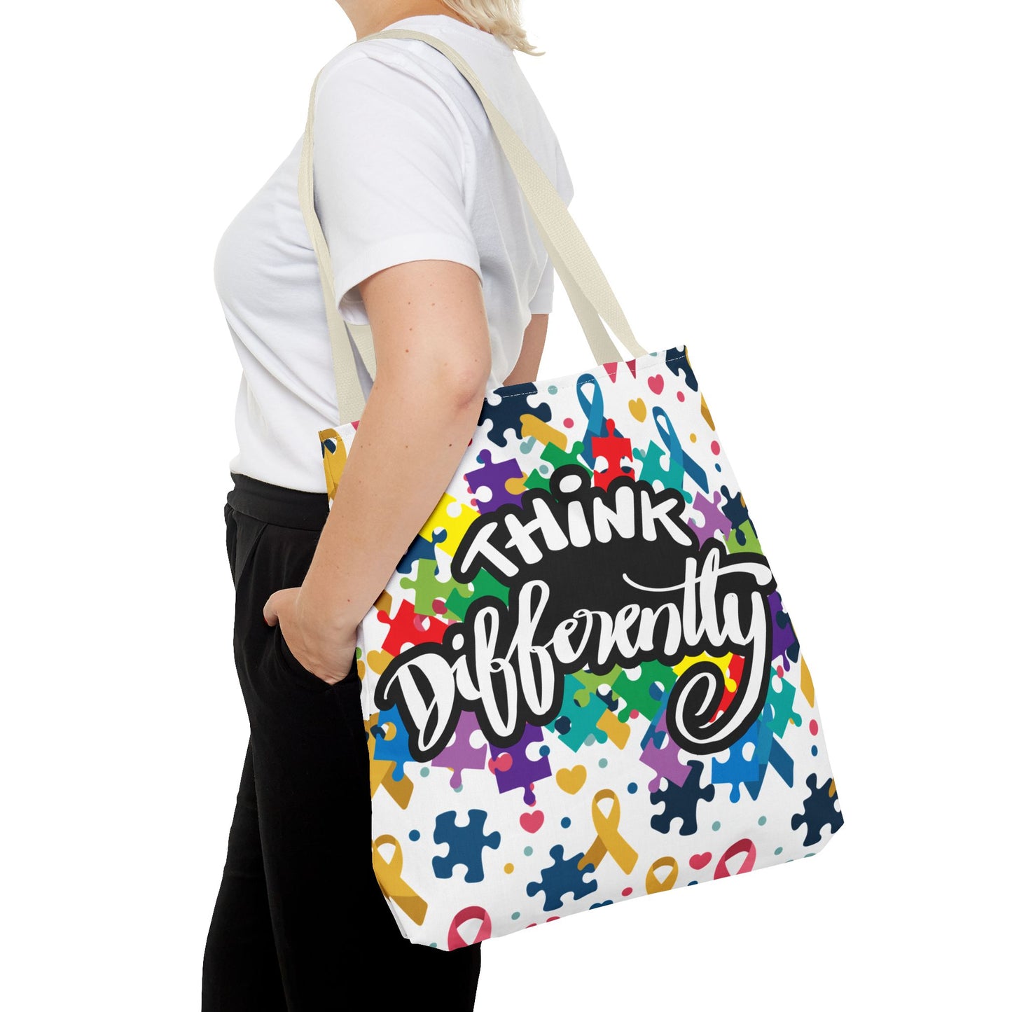 Colorful puzzle ribbon design on Think Differently Autism Awareness tote bag by Printify. Perfect for carrying essentials.