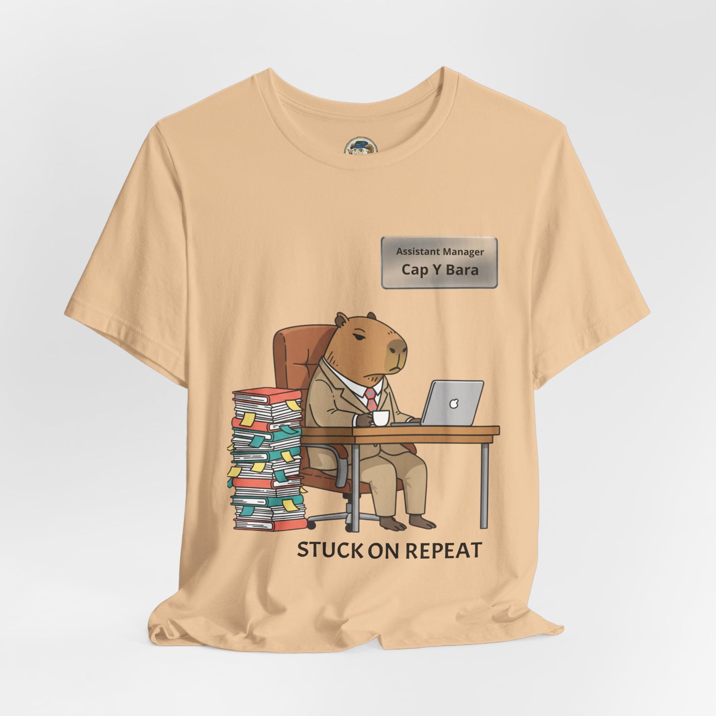 Capybara in suit desk tee with personalized "Stuck on Repeat" nameplate design, casual graphic t-shirt by Printify.