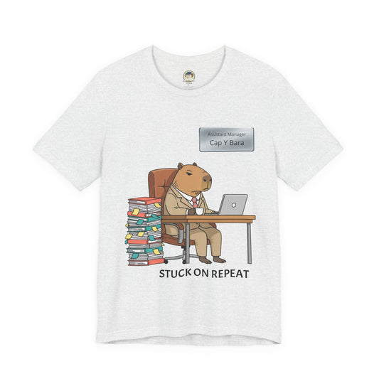 Gray T-shirt featuring a capybara in a suit with the text "Stuck on Repeat" and a personalized nameplate design.