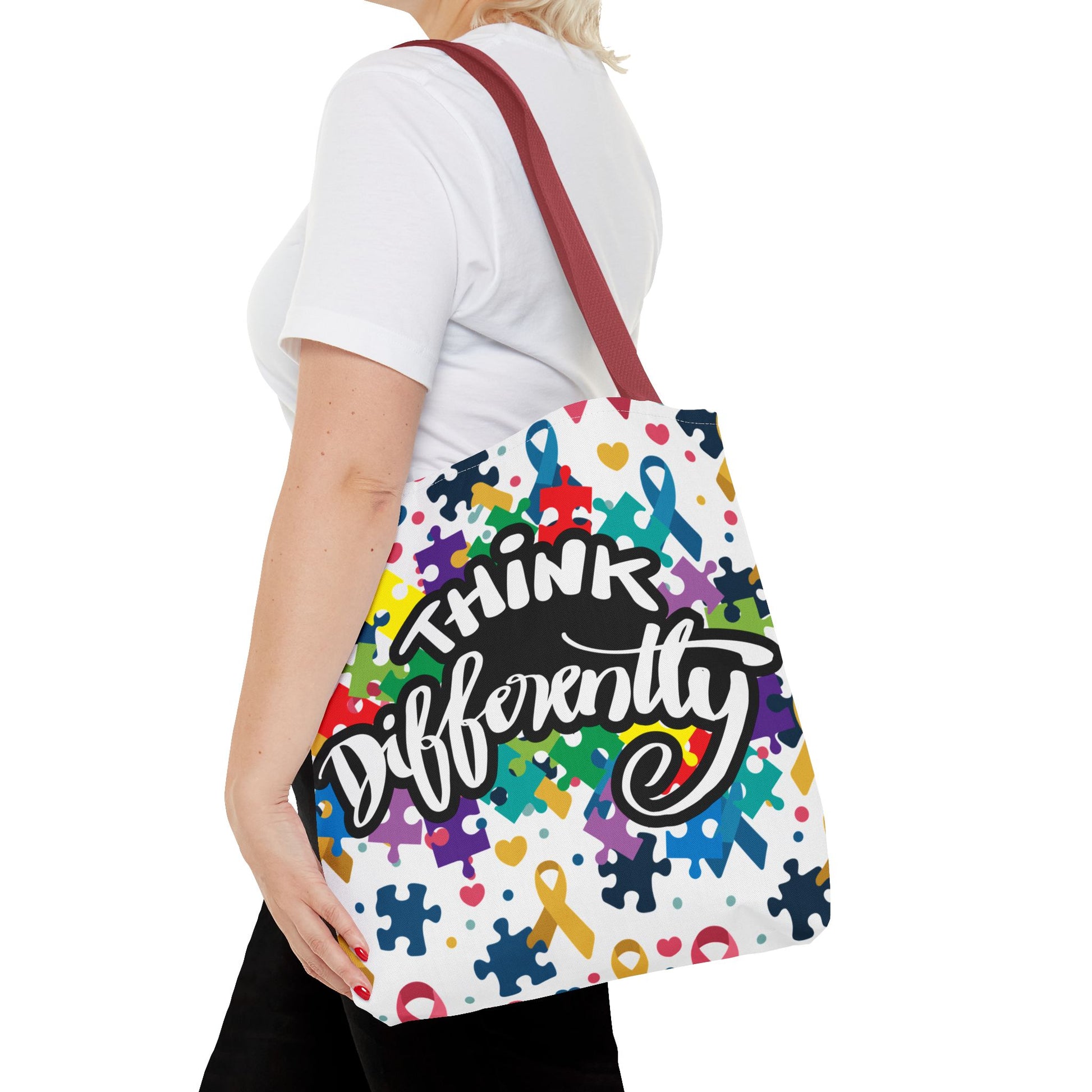 Colorful puzzle ribbon design on Think Differently Autism Awareness tote bag by Printify, showcasing vibrant patterns.