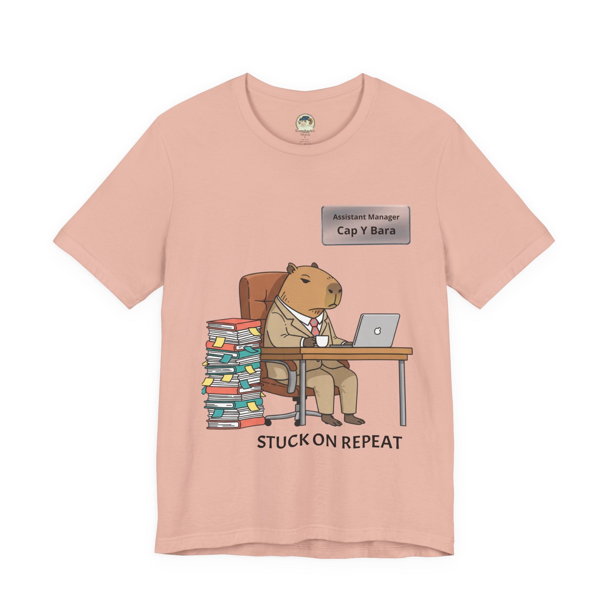 Gray T-shirt featuring a capybara in a suit with "Stuck on Repeat" text and personalized nameplate, by Printify.