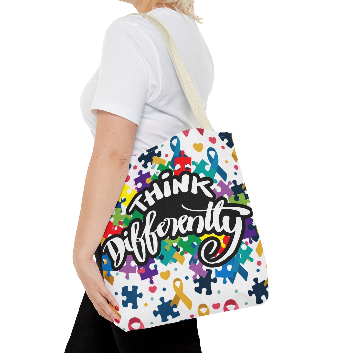Colorful puzzle ribbon design on Think Differently Autism Awareness tote bag by Printify, showcasing vibrant patterns.