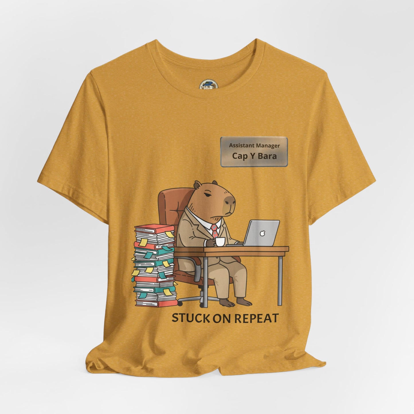 Gray T-shirt featuring a playful capybara in a suit cartoon graphic and personalized "Stuck on Repeat" nameplate design.