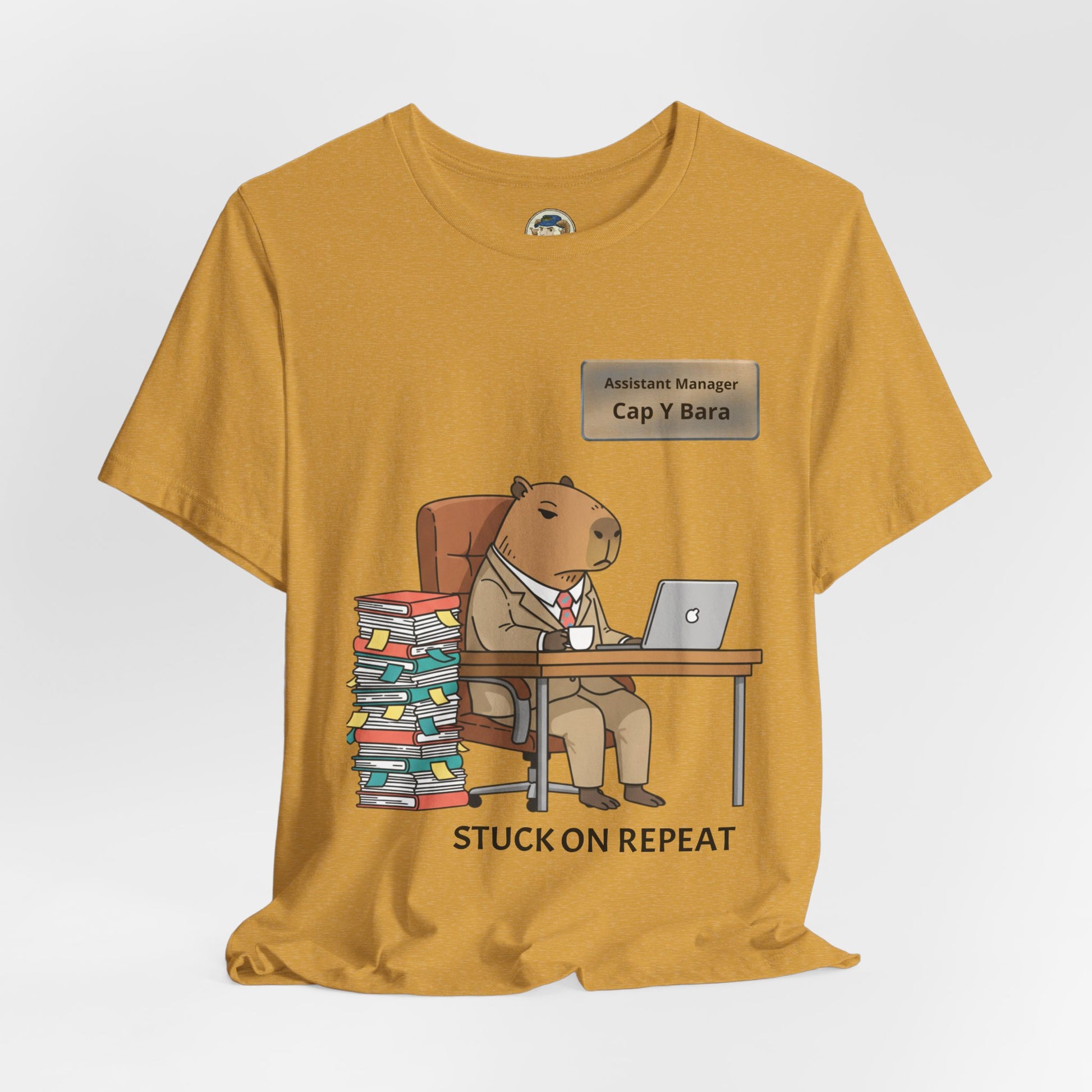 Gray T-shirt featuring a playful capybara in a suit cartoon graphic and personalized "Stuck on Repeat" nameplate design.