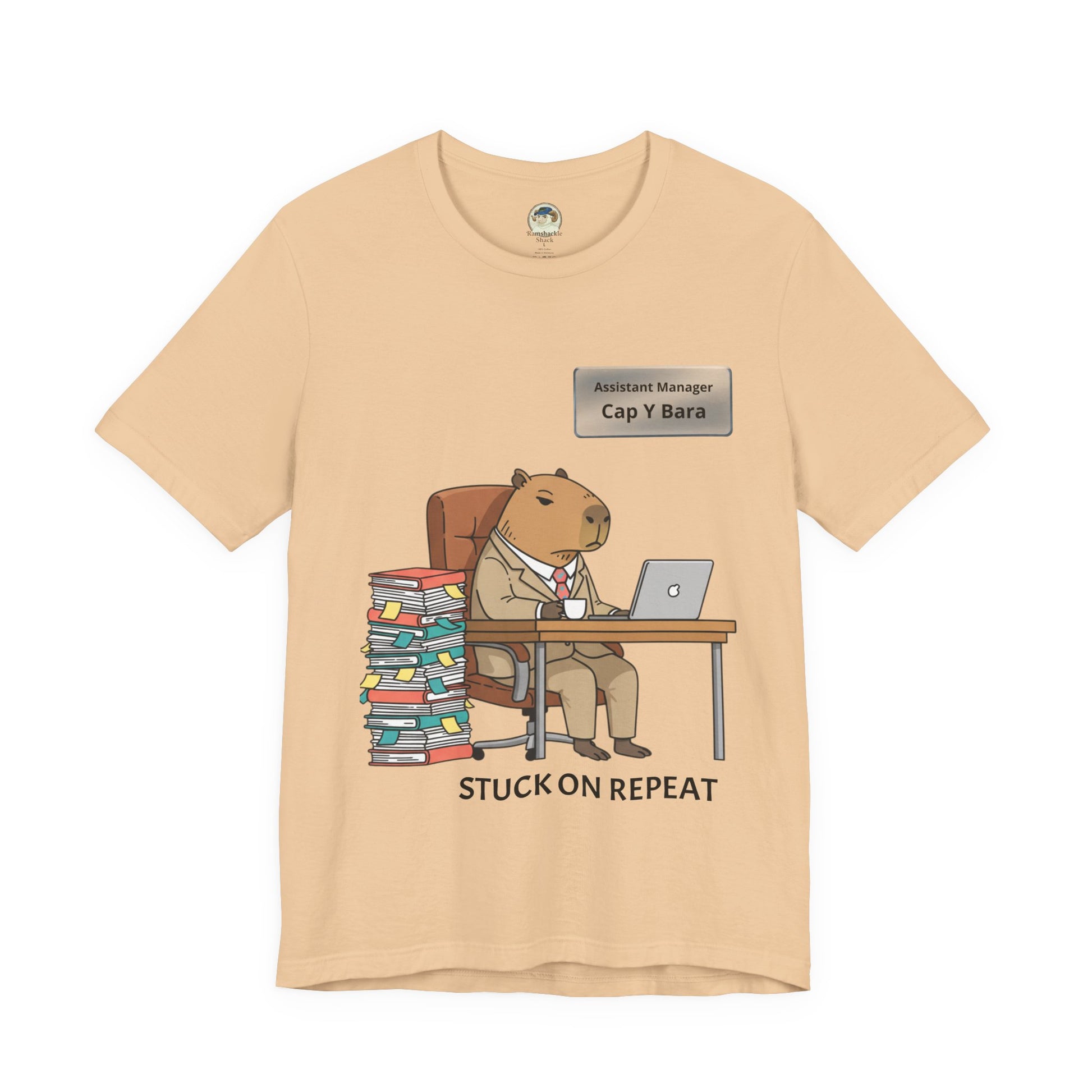 Gray T-shirt featuring a cartoon capybara in a suit with "Stuck on Repeat" text and personalized nameplate design.